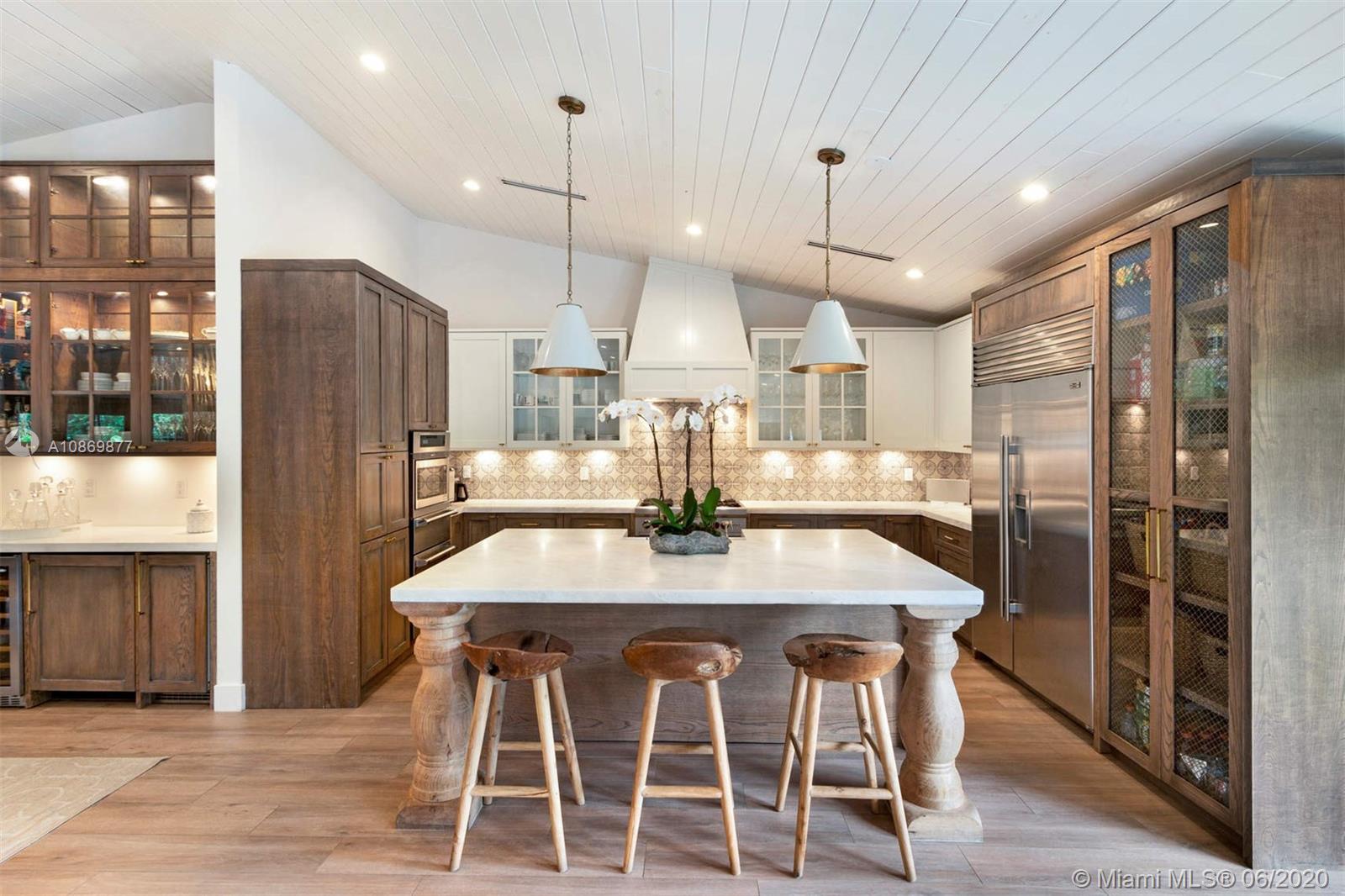 677 Ridgewood Road Key Biscayne, FL 33149 - Photo 8 of 38 a kitchen with stainless steel appliances kitchen island granite countertop a refrigerator a stove a kitchen island a dining table and chairs