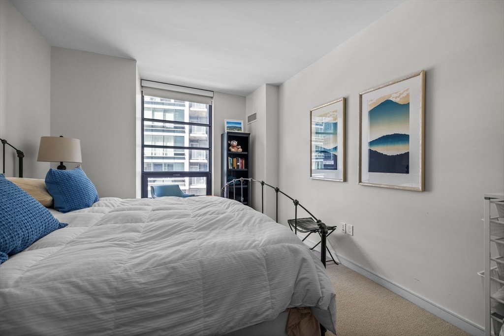 580 Washington Street, Unit 411 Boston, MA 02111 - Photo 11 of 24 a bedroom with a bed and a chandelier