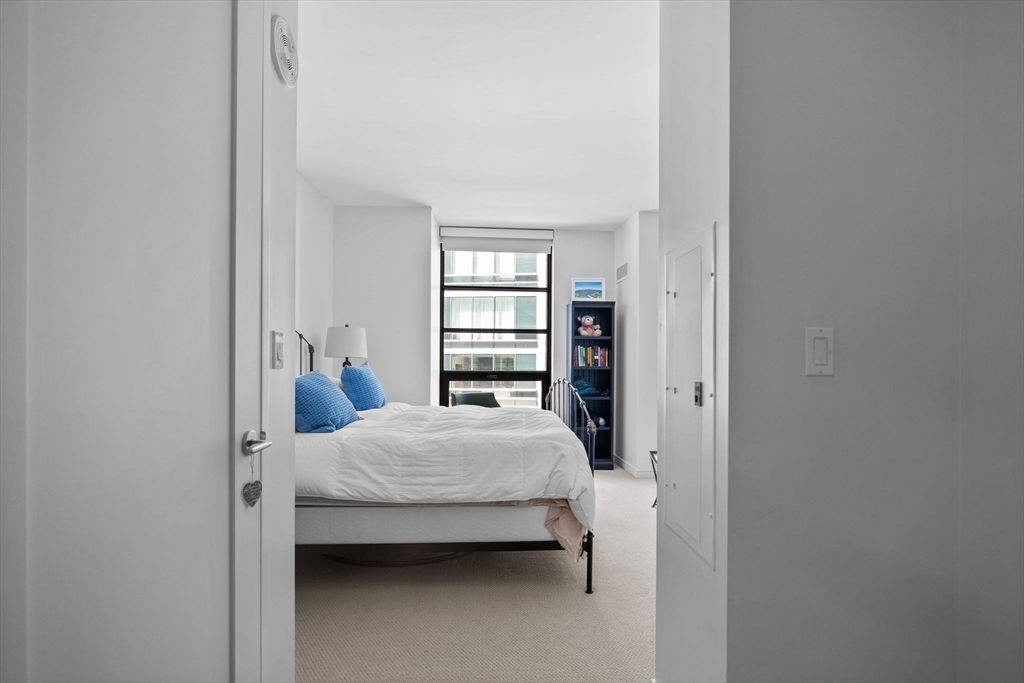 580 Washington Street, Unit 411 Boston, MA 02111 - Photo 12 of 24 a bedroom with a bed and a window