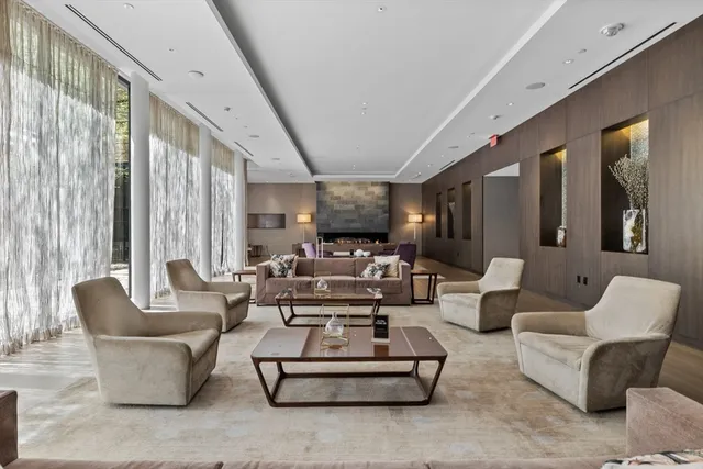 a living room with furniture potted plant and large windows