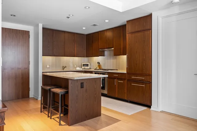 a kitchen with granite countertop a sink cabinets and stainless steel appliances