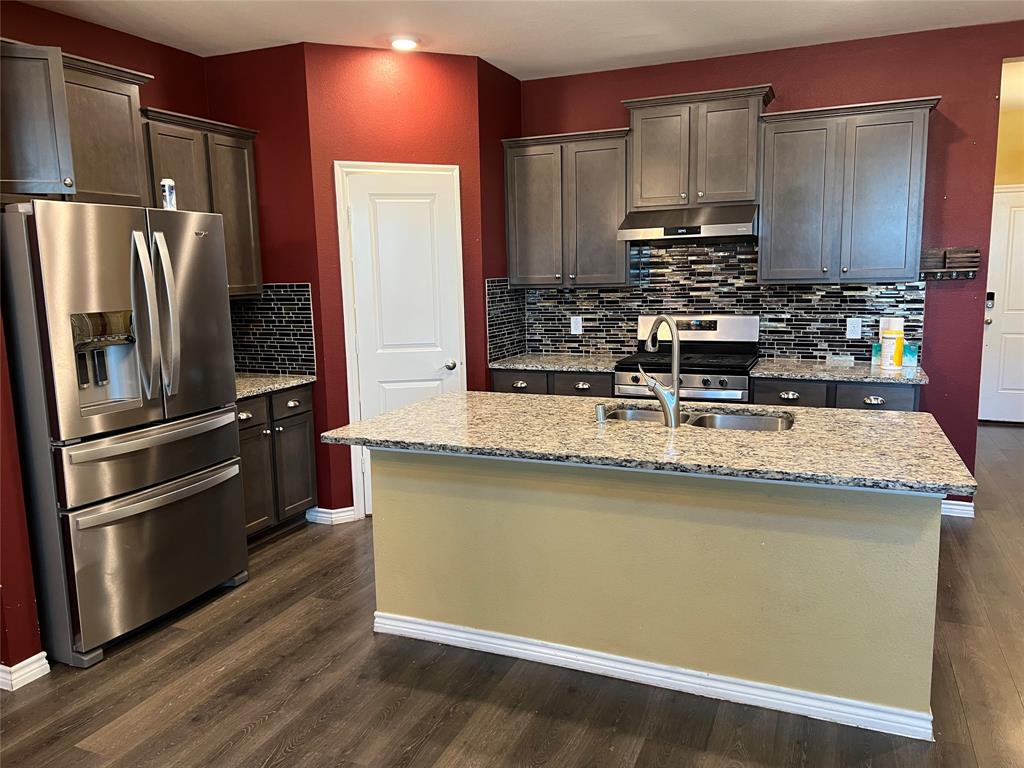 a kitchen with stainless steel appliances a refrigerator a stove a sink and a counter space