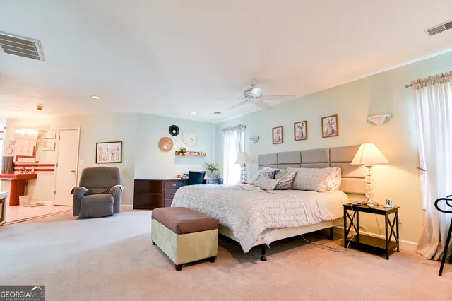 a bedroom with a bed couch and a view of kitchen