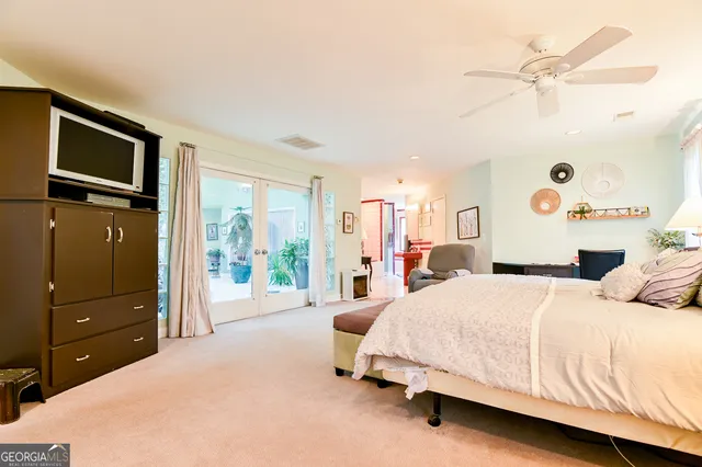 a bedroom with a bed and a dresser with the outer view