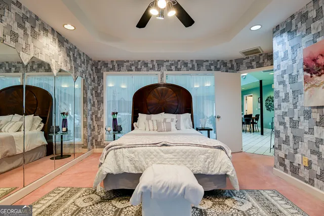 a bedroom with a large bed and a chandelier