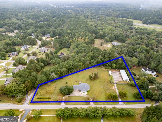 a view of swimming pool with lawn chairs and plants