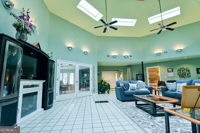 a living room with furniture a flat screen tv and kitchen view