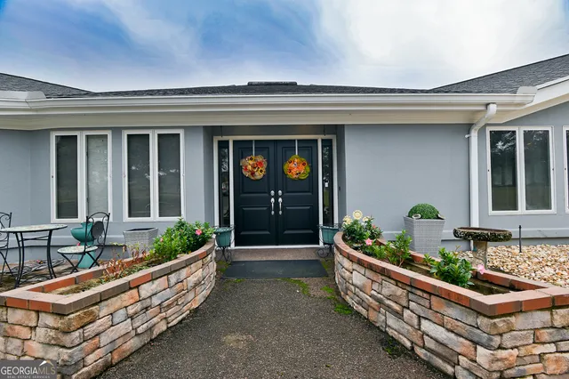 a front view of a house with outdoor seating and plants