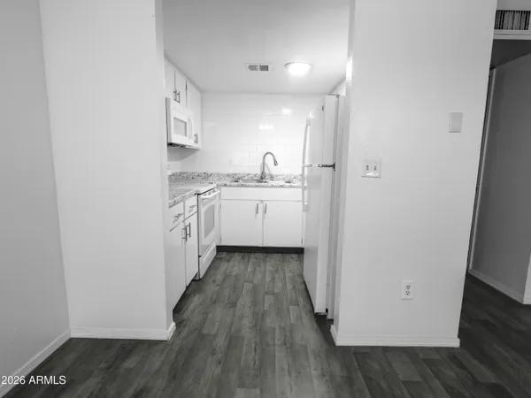 a kitchen with sink and wooden floor