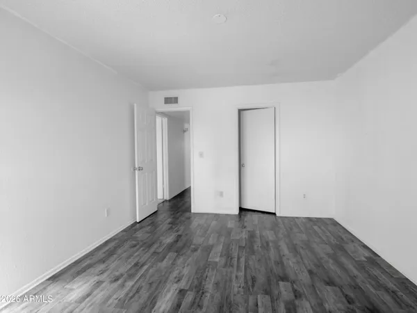 a view of an empty room with wooden floor