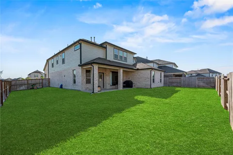 a view of a house with a big yard and large trees