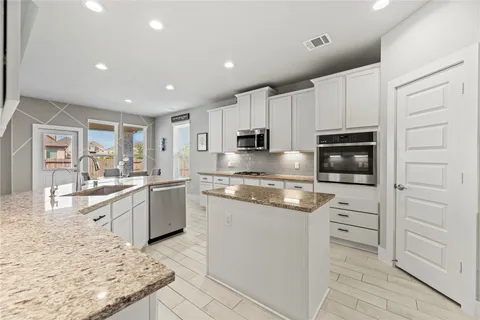 a kitchen with granite countertop cabinets and oven