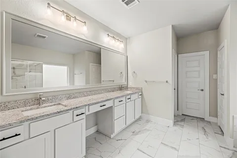 a spacious bathroom with a granite countertop sink a mirror and a