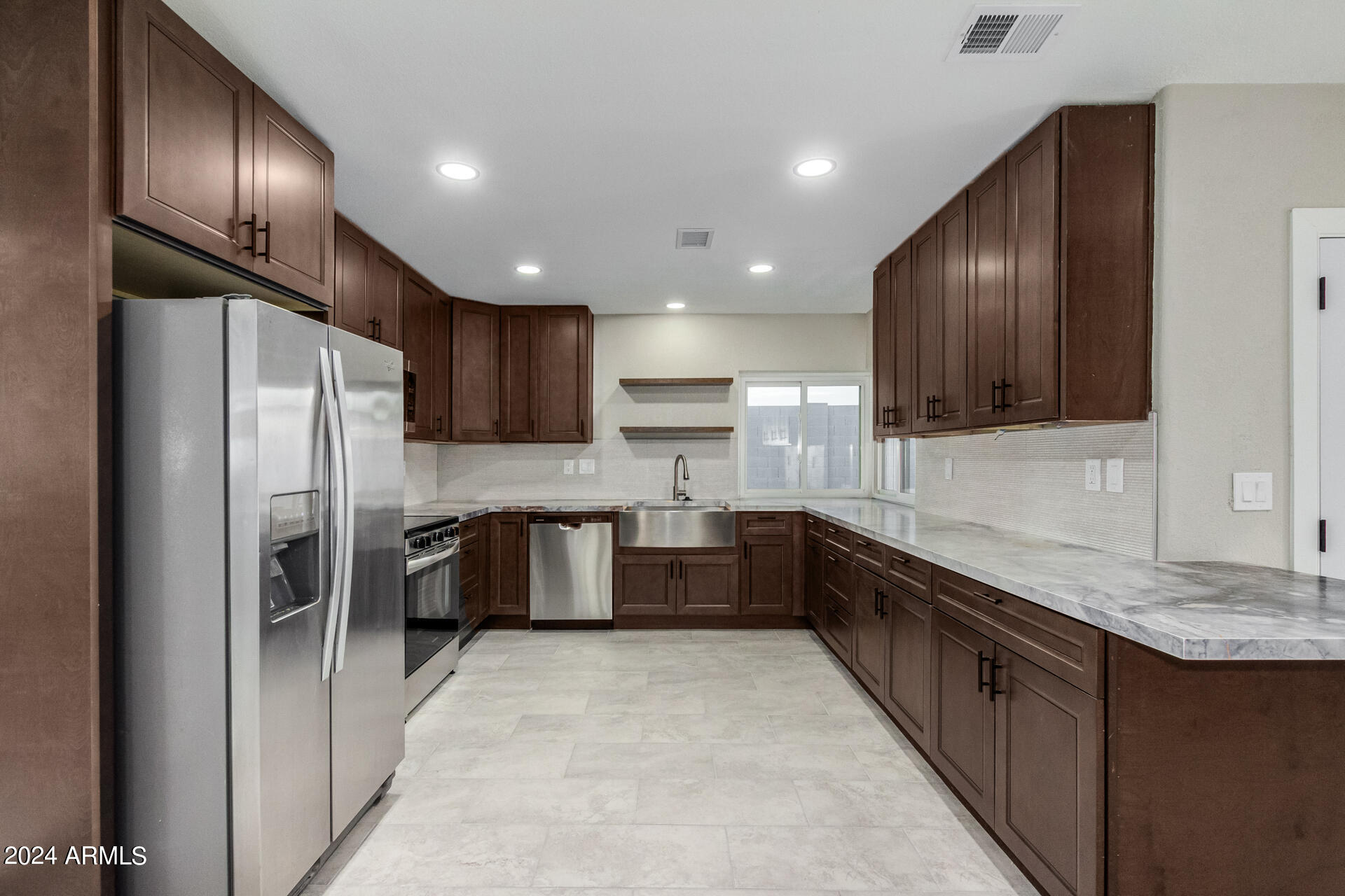 1734 West Banff Ln. Phoenix, AZ 85023 - Photo 11 of 44 a large kitchen with a large island in the center a sink stainless steel appliances and cabinets