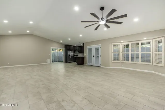 a view of a livingroom with a ceiling fan and windows