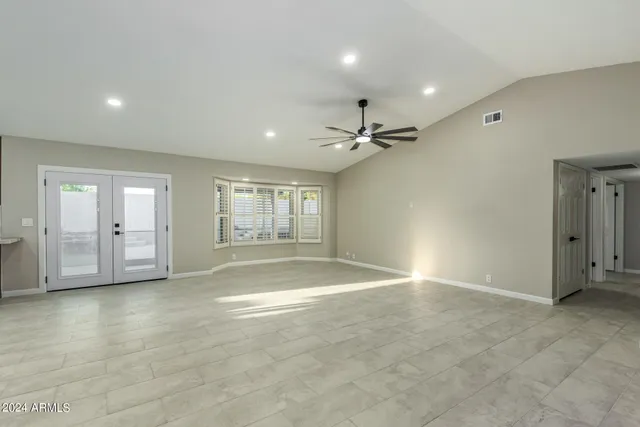 a large kitchen with a large island in the center a sink stainless steel appliances and cabinets