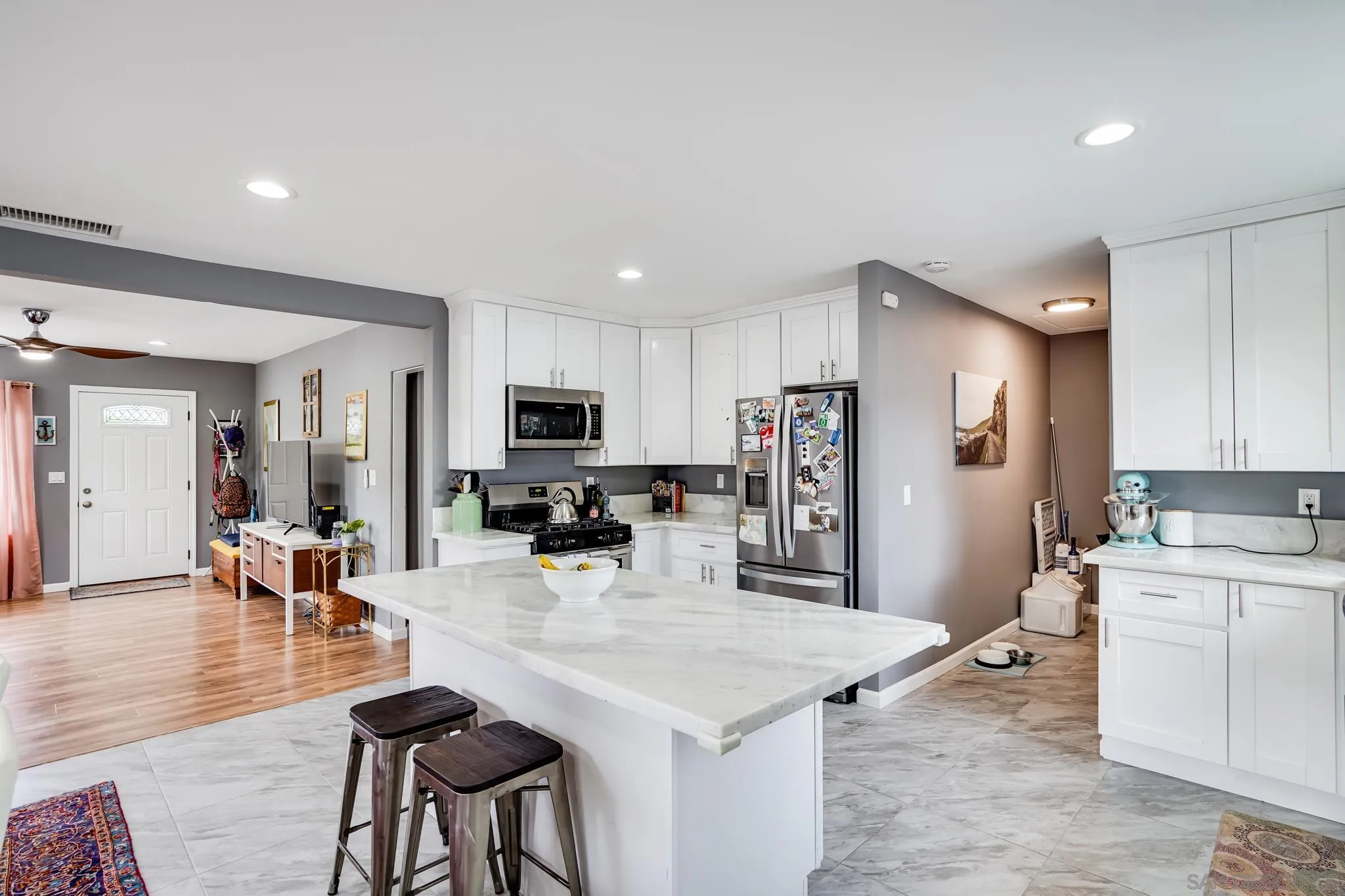 7690 Canton Drive Lemon Grove, CA 91945 - Photo 7 of 41 a kitchen with stainless steel appliances a sink a stove a refrigerator cabinets and a dining table