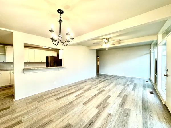 a view of a room with wooden floor and a ceiling fan