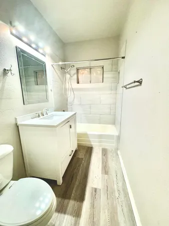 a bathroom with a sink a toilet a mirror and shower