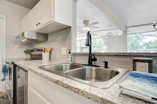 a kitchen with granite countertop a sink and a stove