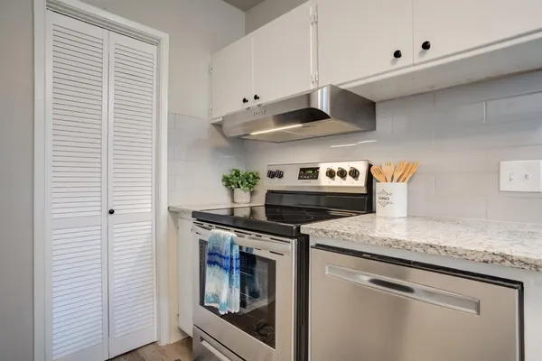 a kitchen with stainless steel appliances granite countertop a sink and a stove