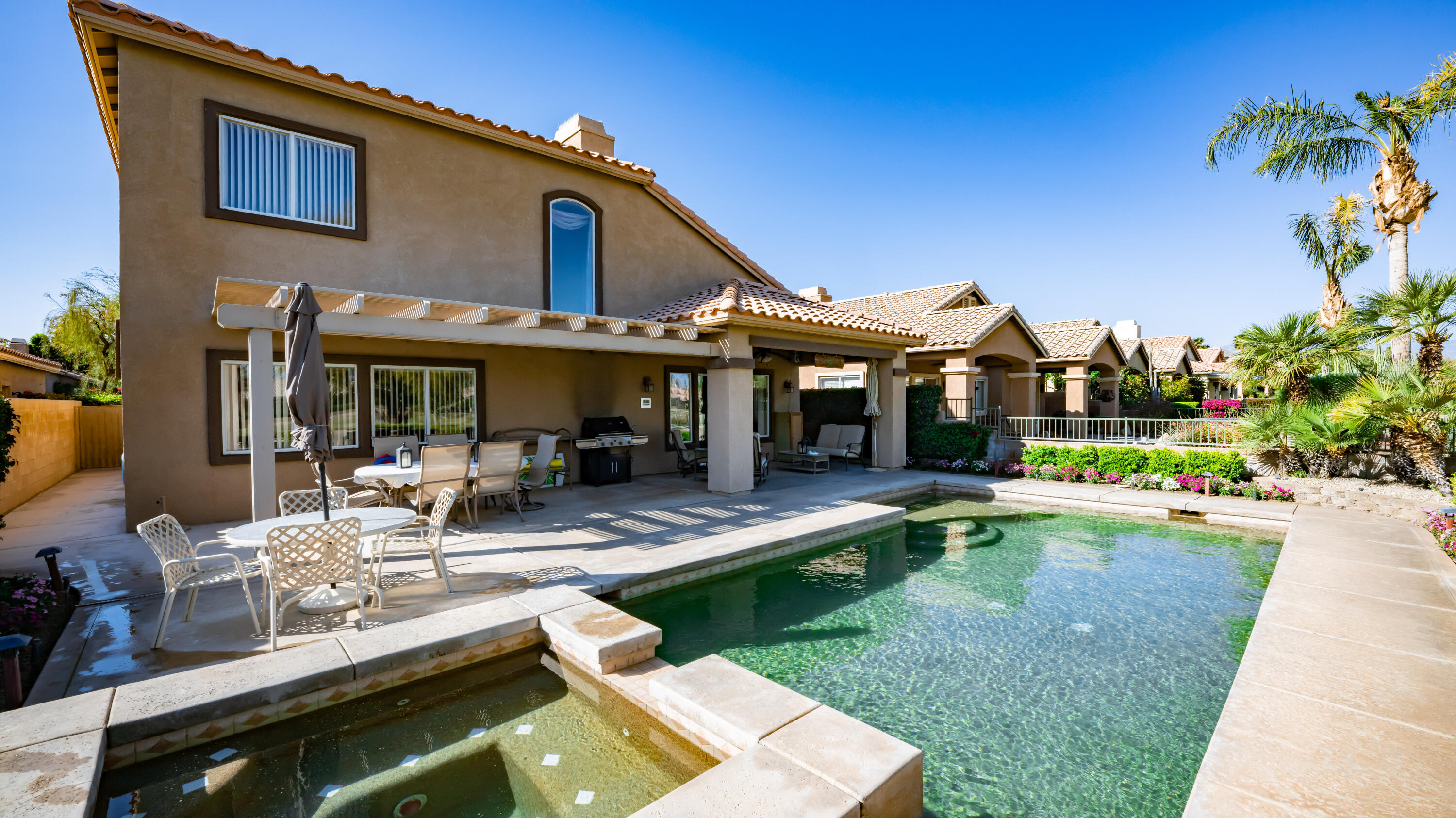 a view of a house with swimming pool and sitting area