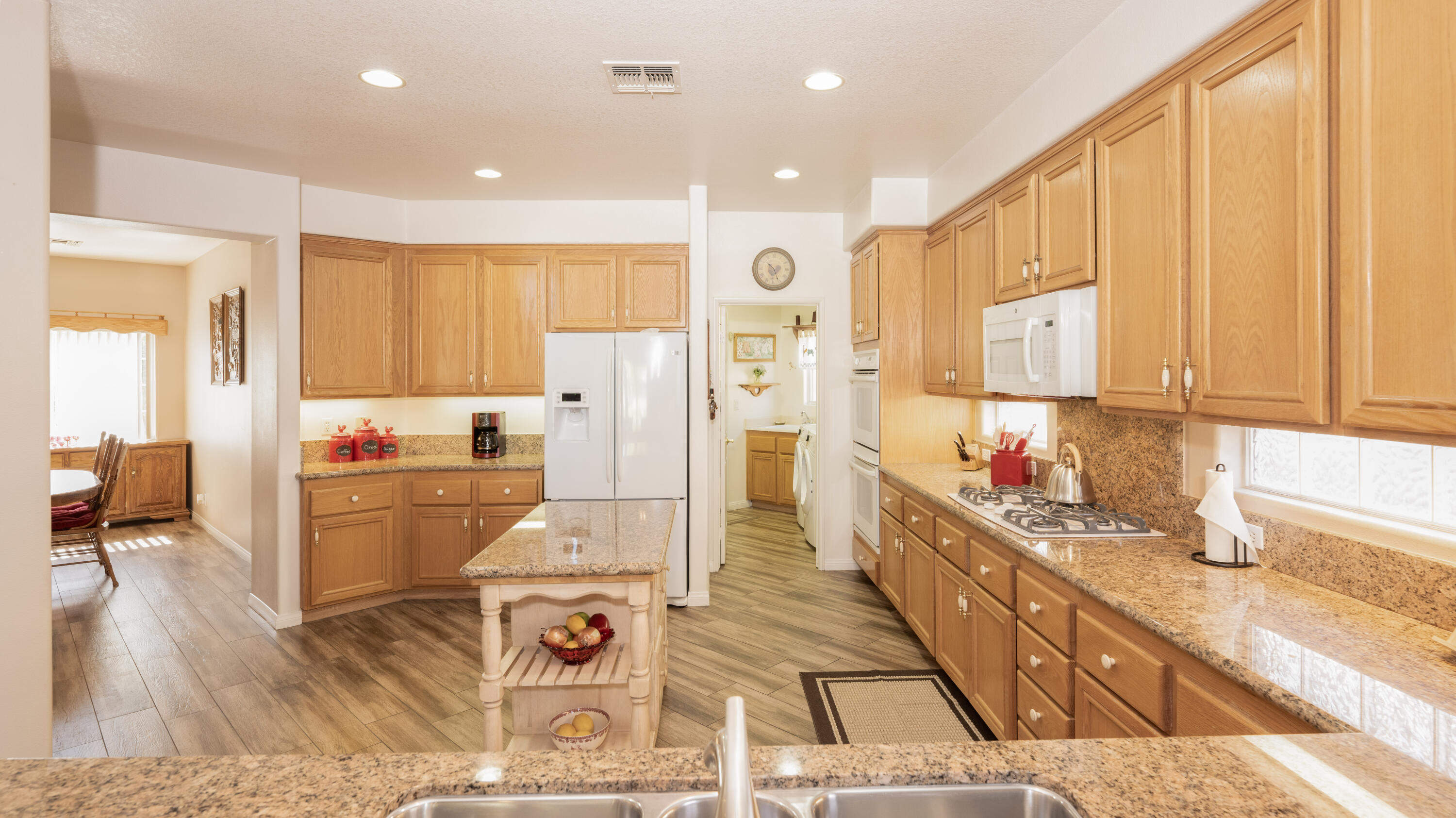 80432 Pebble Beach Drive Indio, CA 92201 - Photo 13 of 46 a large white kitchen with wooden floor and stainless steel appliances