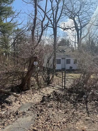 a view of house with backyard and trees