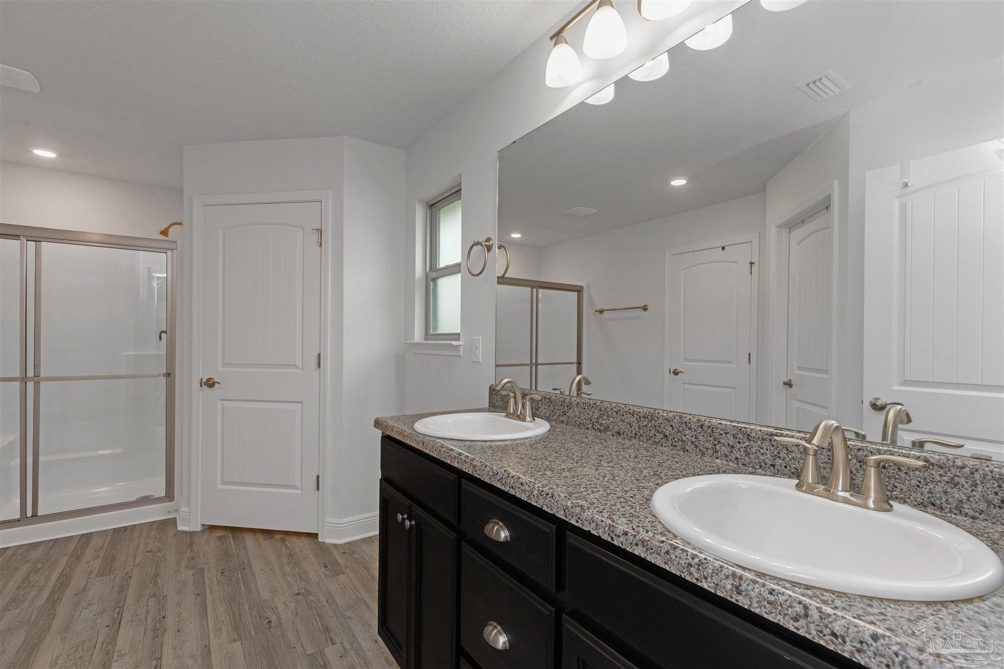 3626 Ranch Drive Crestview, FL 32539 - Photo 16 of 29 a bathroom with a granite countertop sink a large mirror and a shower