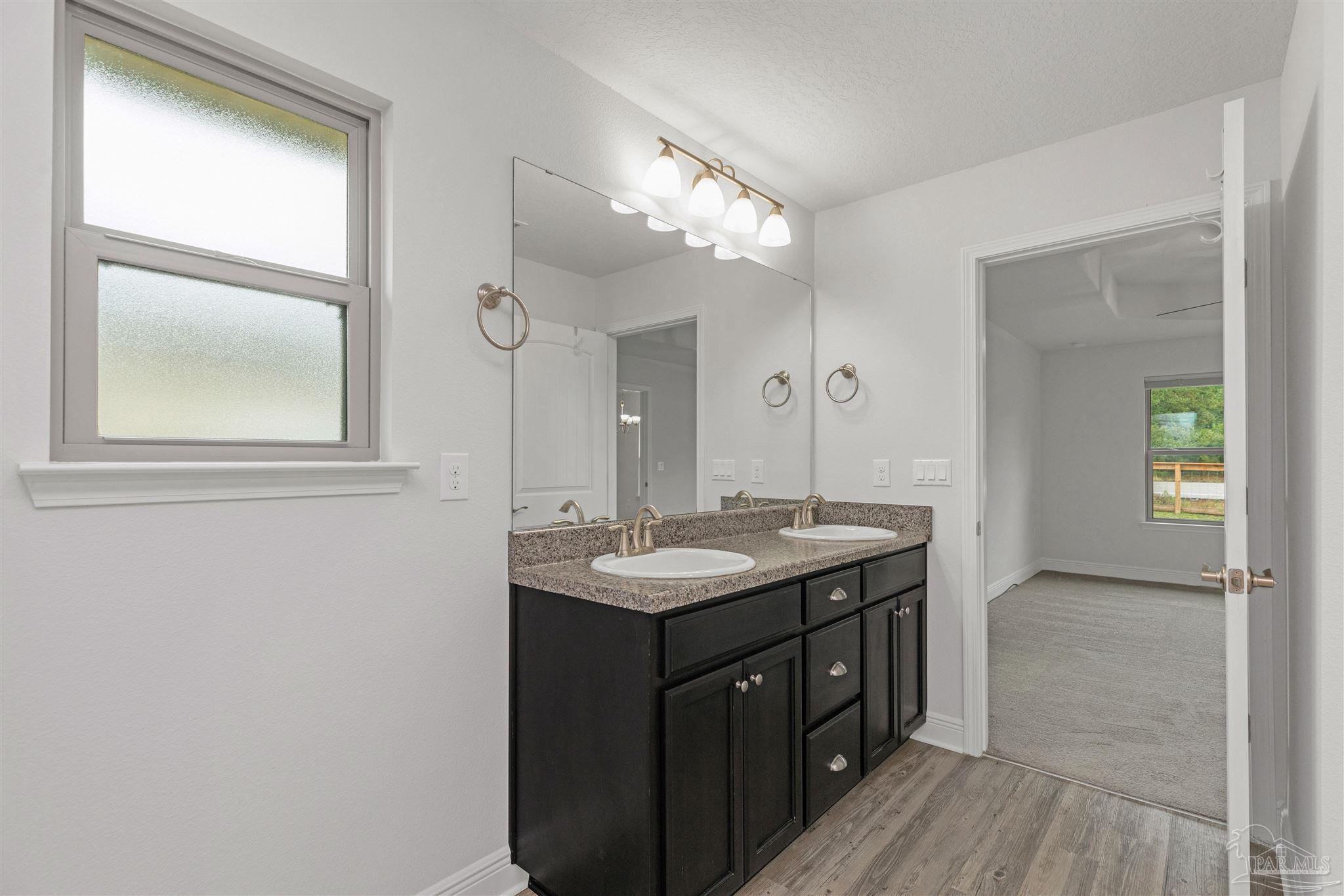 3626 Ranch Drive Crestview, FL 32539 - Photo 17 of 29 a bathroom with a granite countertop sink a mirror and a vanity