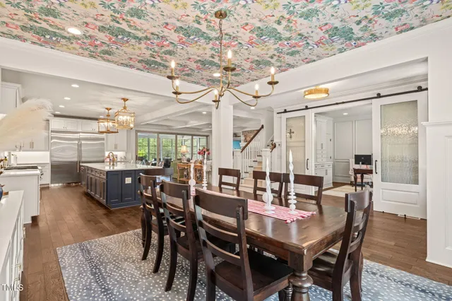 a living room with furniture a rug kitchen view and a chandelier