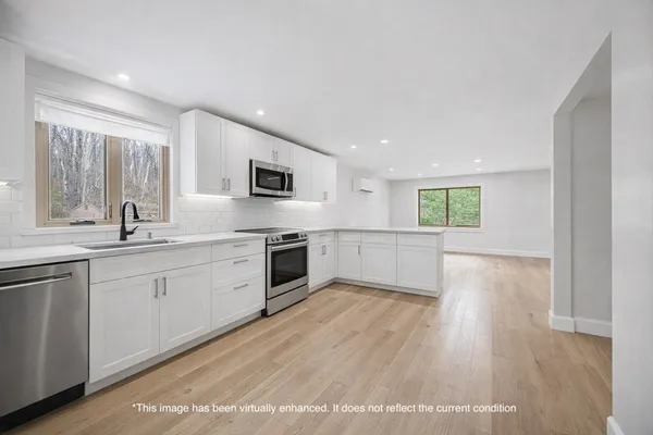 a view of an empty room with a fireplace and a window