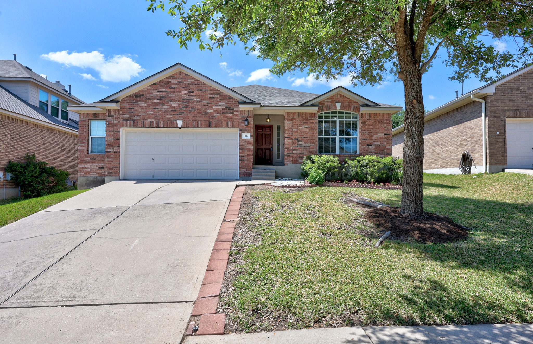 1317 Rimstone Drive Cedar Park, TX 78613 - Photo 1 of 32 Ranch-style house with an attached garage, brick siding, driveway, and a front lawn
