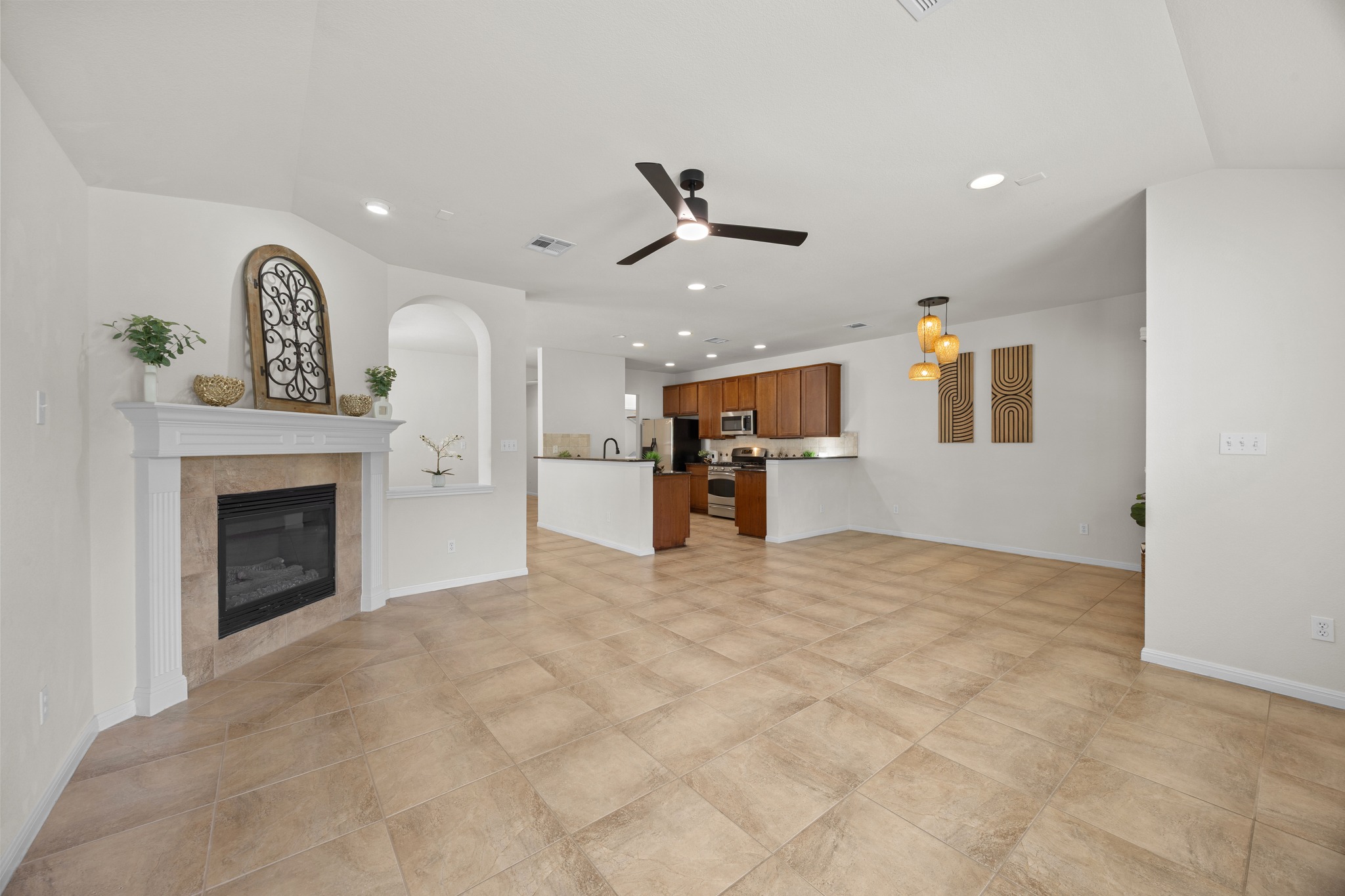 1317 Rimstone Drive Cedar Park, TX 78613 - Photo 14 of 32 Unfurnished living room with a tiled fireplace, recessed lighting, a ceiling fan, and arched walkways