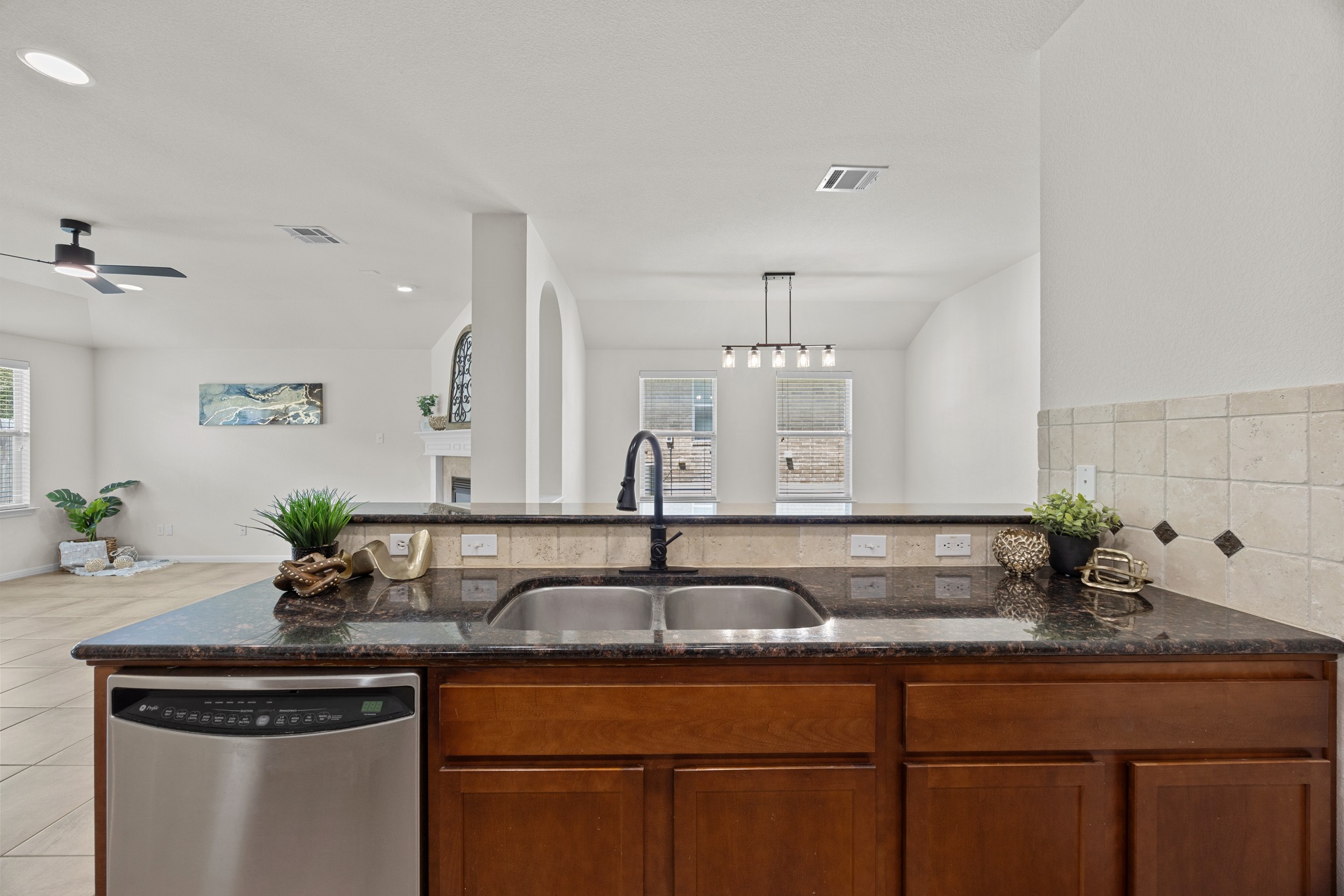 1317 Rimstone Drive Cedar Park, TX 78613 - Photo 32 of 32 Kitchen with dark stone counters, stainless steel dishwasher, pendant lighting, open floor plan, and a ceiling fan