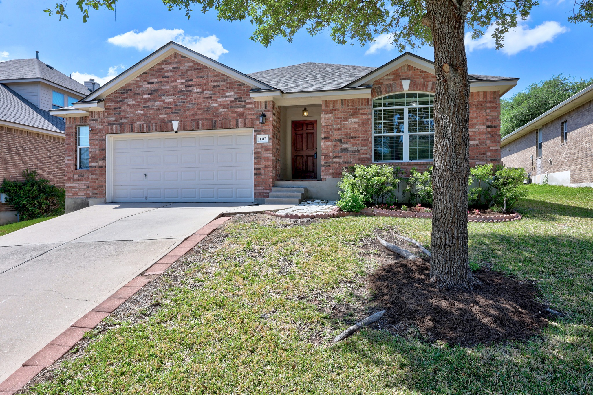 1317 Rimstone Drive Cedar Park, TX 78613 - Photo 2 of 32 Ranch-style home with brick siding, concrete driveway, a garage, a front yard, and roof with shingles