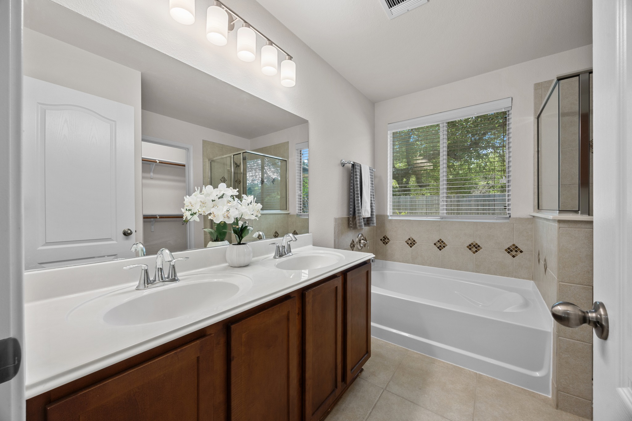 1317 Rimstone Drive Cedar Park, TX 78613 - Photo 24 of 32 Full bathroom with double vanity, a spacious closet, a garden tub, a shower stall, and light tile patterned floors