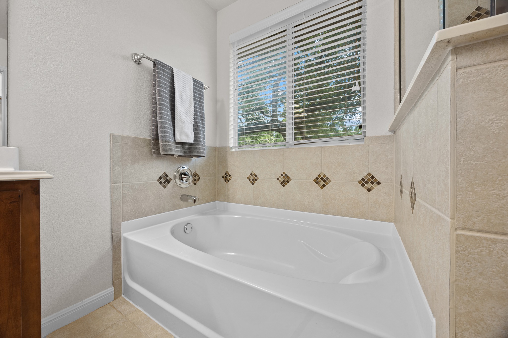 1317 Rimstone Drive Cedar Park, TX 78613 - Photo 26 of 32 Bathroom featuring a bath, vanity, a textured wall, and light tile patterned floors