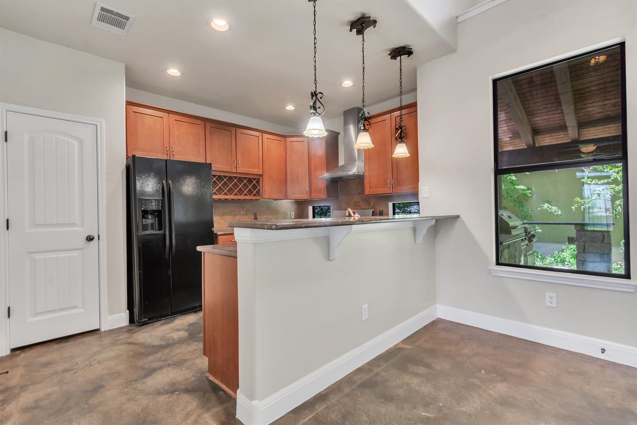 1010 Immanuel Road, Unit 103 Pflugerville, TX 78660 - Photo 18 of 30 A well-appointed kitchen features rich wooden cabinetry, stone countertops, and a practical breakfast bar.
