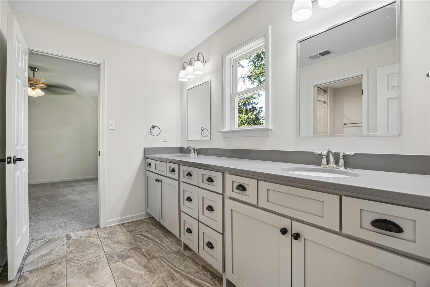 8970 Farmoor Road Germantown, TN 38139 - Photo 26 of 35 Bathroom featuring a double vanity with grey countertops and integrated sinks, white cabinetry with dark hardware, and tile flooring