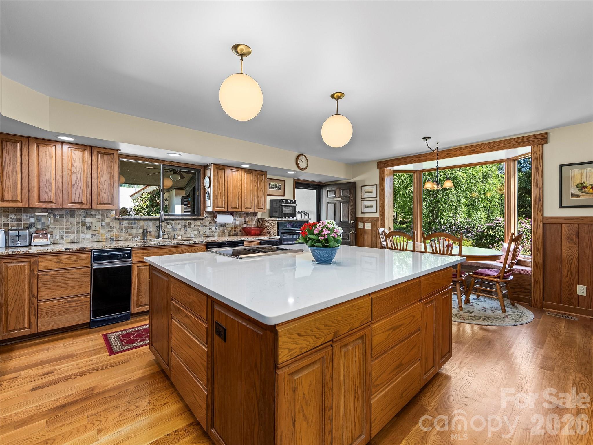 69 Forest Road Asheville, NC 28803 - Photo 11 of 48 a kitchen with kitchen island granite countertop a sink a stove and a wooden floors