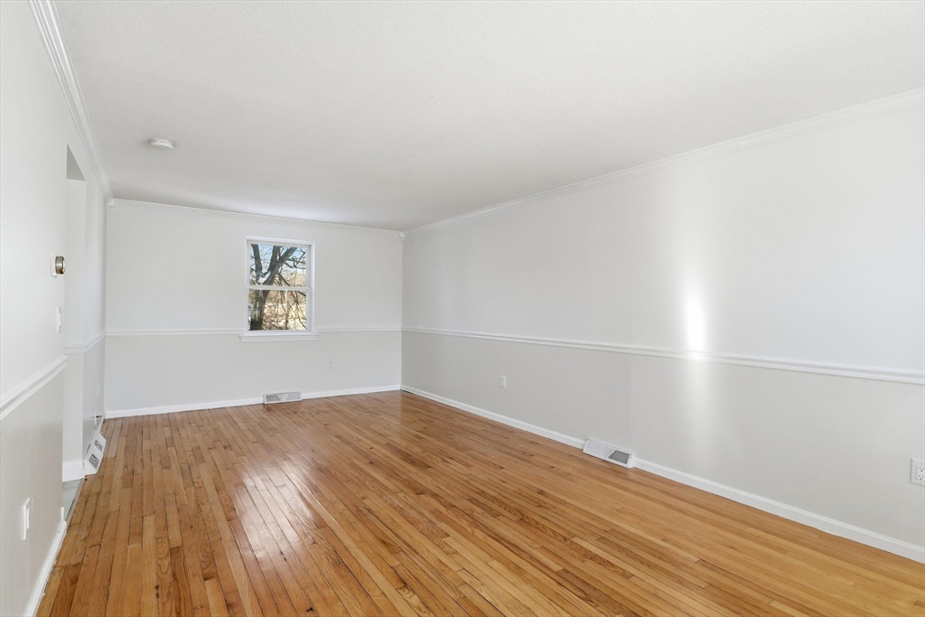 22 Pheasant Drive Springfield, MA 01119 - Photo 11 of 40 an empty room with wooden floor and windows