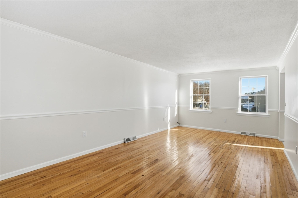 22 Pheasant Drive Springfield, MA 01119 - Photo 13 of 40 an empty room with wooden floor and windows