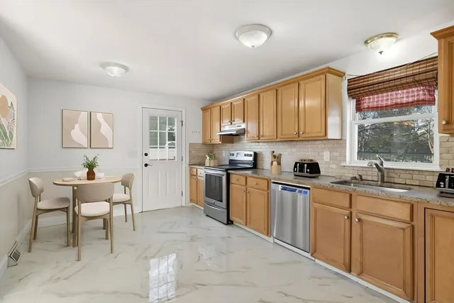 a kitchen with granite countertop a sink window and cabinets