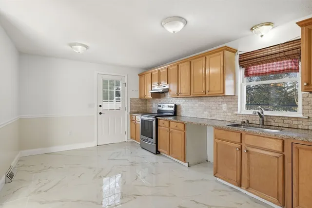 a view of a kitchen with a sink and a refrigerator