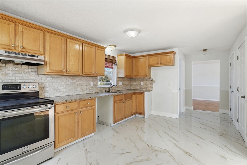 22 Pheasant Drive Springfield, MA 01119 - Photo 20 of 40 a kitchen with granite countertop a stove sink and cabinets