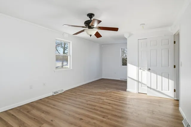 a view of empty room with wooden floor
