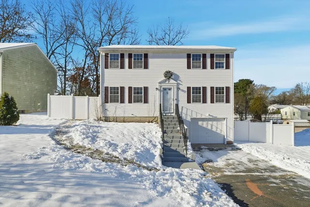a front view of a house with a yard covered in snow