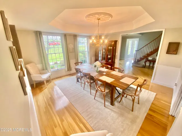 a view of an empty room with window wooden floor and a kitchen view