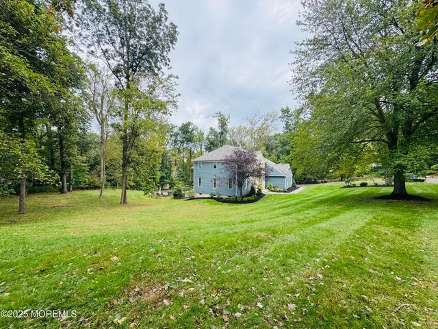 a backyard of a house with plants and large trees